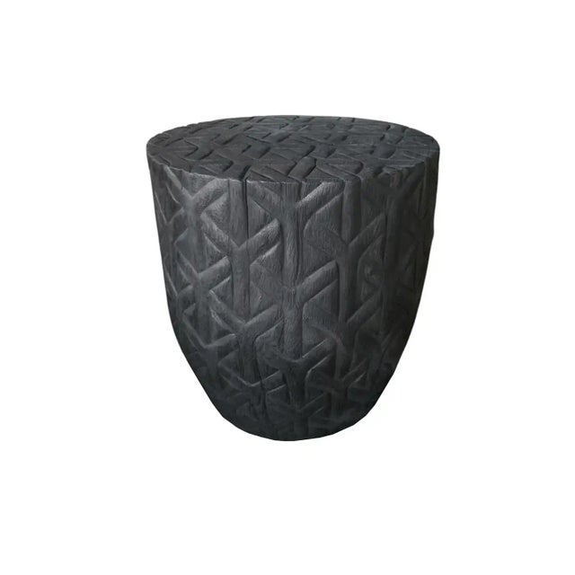 A wonderfully sculptural side table with a geometric pattern hand-carved on all sides. Its rich black pigment was achieved...