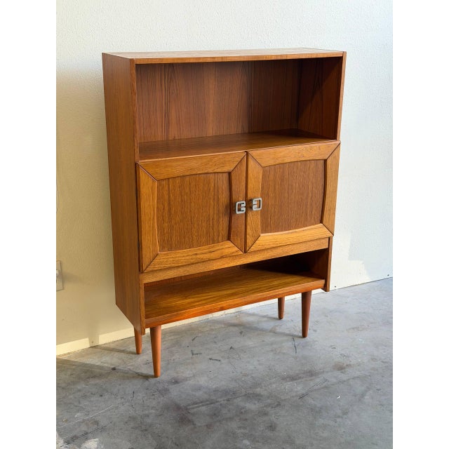 Beautiful vintage Danish mid-century modern teak cabinet, showcasing the clean lines, warm wood tone, and functional...