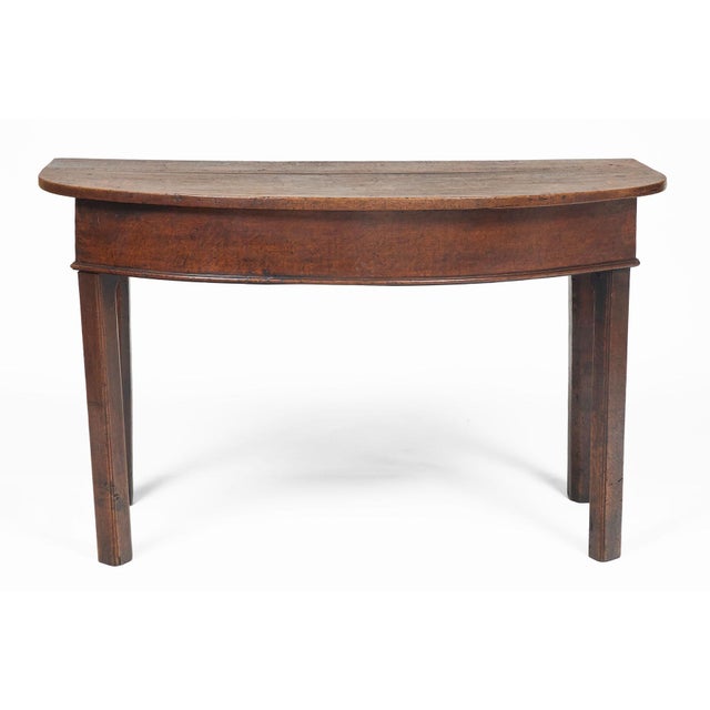 English George II black oak D-end table atop a plain bowfront frieze with straight ends, molded bottom edge, supported on...