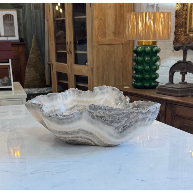 Carved from a single piece of natural onyx, this substantial decorative vessel showcases dramatic banding in soft ivory,...