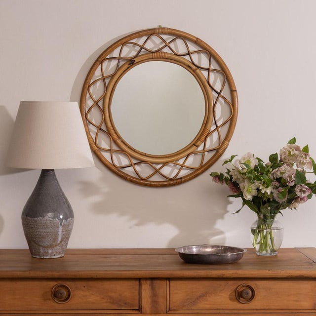 Beautiful wavy rattan circular mirror from Italy, 1960s. Unique design with wavy zig-zag rattan encompassing the mirror....