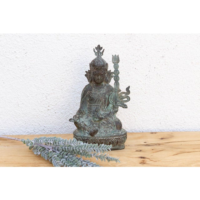 This 11-inch bronze figure depicts a seated Buddha in a state of profound meditation, likely originating from the Thai or...