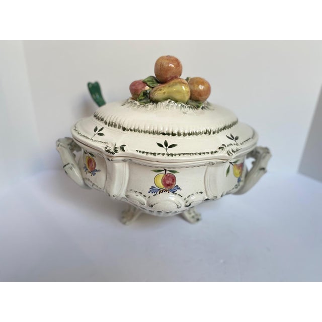 An elegant early to mid 20th-century French faience footed oval tureen. Hand-painted with fruit and leaf decoration....