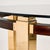 A dining table with classic lines from the 1970s. The table has a mahogany and brass frame, a smoked glass top, and the...