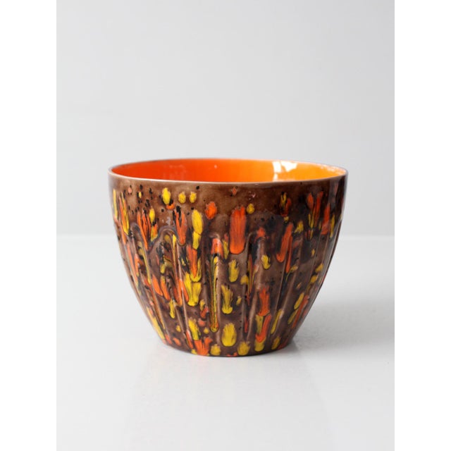 A mid-century Ox Mould pottery bowl featuring a vivid orange glazed interior and a richly textured brown exterior with...