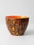 A mid-century Ox Mould pottery bowl featuring a vivid orange glazed interior and a richly textured brown exterior with...