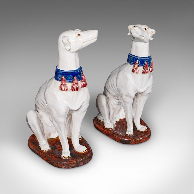 This is a pair of vintage Greyhound figures. An Italian, ceramic seated dog statue or decorative bookends, dating to the...