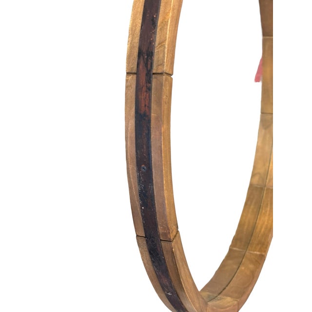 Handcrafted round all mirror featuring a segmented wood frame reinforced with a dark patina metal band. The architectural...