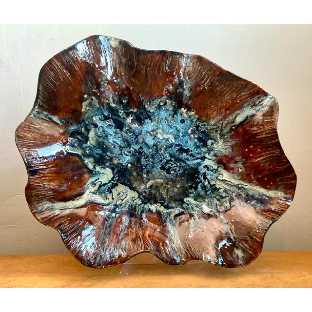 This vintage ceramic dish is a bold, free-form piece of studio pottery, shaped like a wide, shallow, ruffled leaf or open...