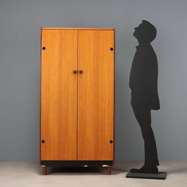 Vintage Italian-made storage unit with two hinged doors in teak veneer with stained wood inserts. This piece is attributed...