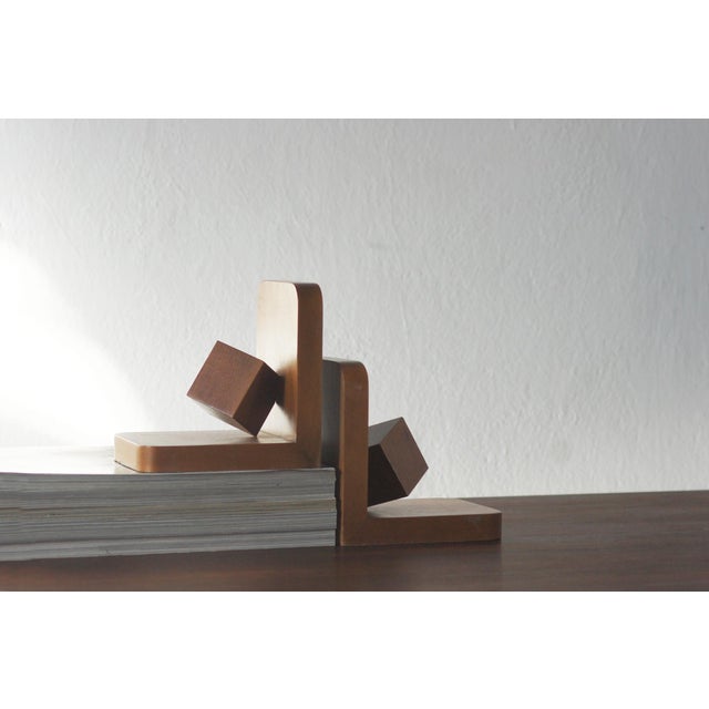 These wooden bookends from the 1950s represent the aesthetics of post-war modernism—minimalist, geometric, and subordinate...