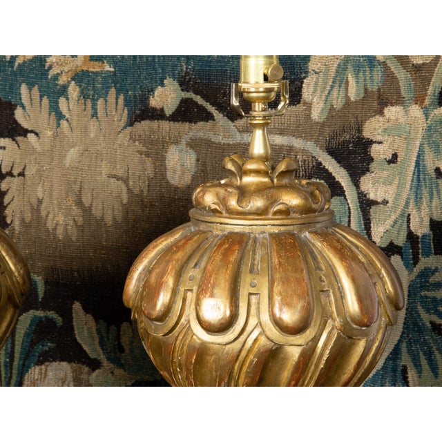 A pair of Italian carved giltwood fragments from the 19th century made into table lamps and mounted on custom lucite...
