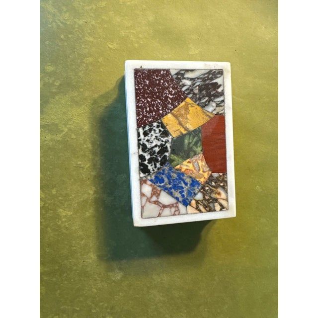 The white ground inlaid with specimen marbles and porphyry with ridges on 2 sides