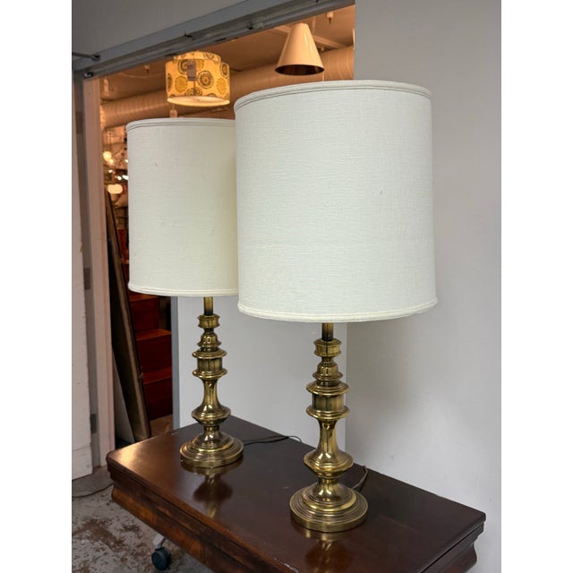 Design Plus Gallery presents a Pair of Vintage Brass Table Lamps. This vintage pair has turned brass forms with tiered...