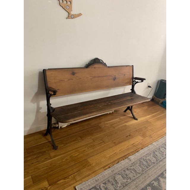 This is an antique 19th-century schoolhouse bench. The cast-iron sides are stamped "BAKER, PRATT & CO. N.Y." on one arm...