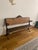 This is an antique 19th-century schoolhouse bench. The cast-iron sides are stamped "BAKER, PRATT & CO. N.Y." on one arm...