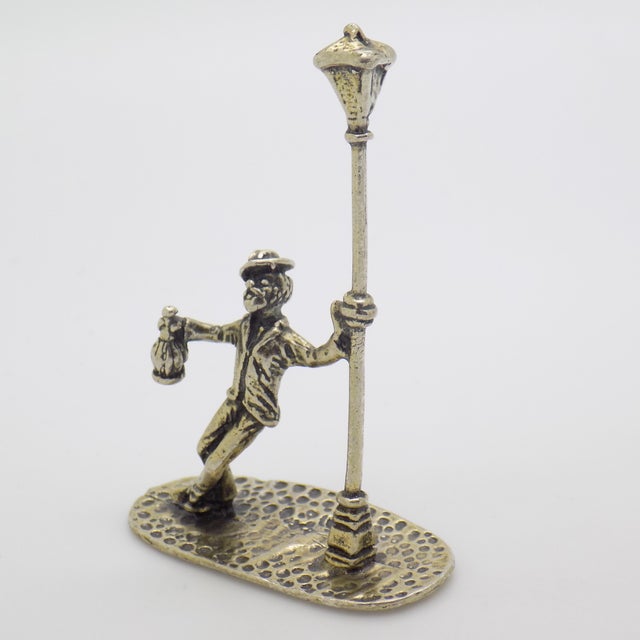 A lively and humorous vintage miniature depicting a drunken man leaning against a street light, handcrafted in Italy...