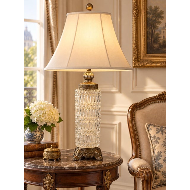 A monumental vintage French Neoclassical table lamp combining a tall, brilliantly patterned crystal body with ornate...