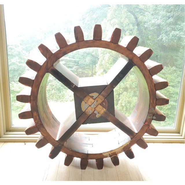 A large reclaimed antique industrial wooden foundry toothed cogwheel gear mold as a modern free-standing or wall...