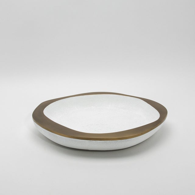 The Lily Bowl in white shagreen with bronze patina brass details by R&Y Augousti exudes refined elegance through its...