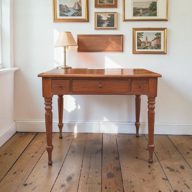 A character-rich antique writing desk with a substantial solid-wood work surface, turned legs and a practical center...