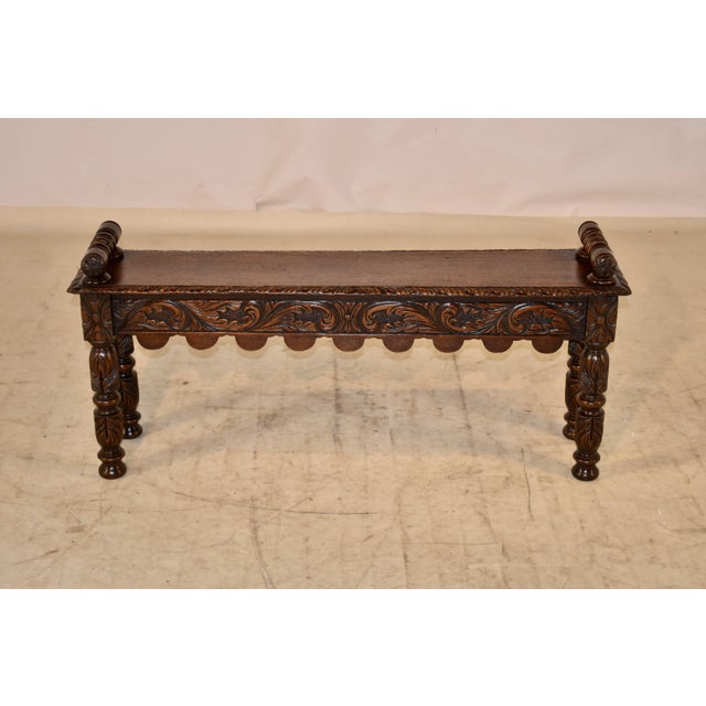 19th century oak window seat from England. This piece has lovely hand carved decorated arms attached to the seat, which is...