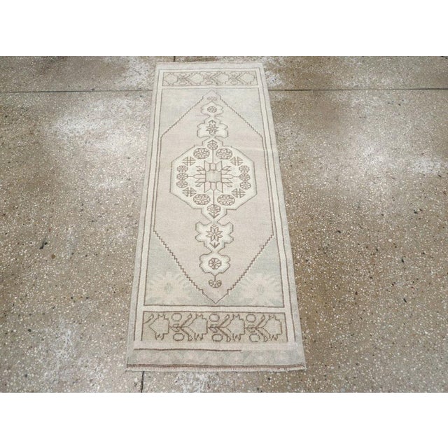A wool pile of symmetric knots on a wool foundation. The soft, open, minutely stepped hexagonal beige field centrally...