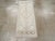 A wool pile of symmetric knots on a wool foundation. The soft, open, minutely stepped hexagonal beige field centrally...