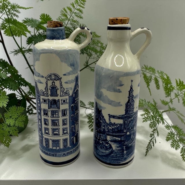 These miniature ceramic jugs feature hand-painted Delft blue designs depicting iconic Amsterdam landmarks, including...