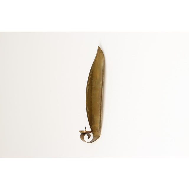 Wall sconce by Hans Heck in the shape of a lancet leaf with a candle holder, hammered brass. Created between the 1930s and...