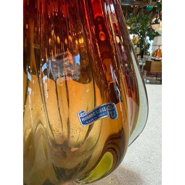 Hand-blown Murano glass ewer vase featuring a graceful elongated spout and curled handle, executed in a warm sommerso...