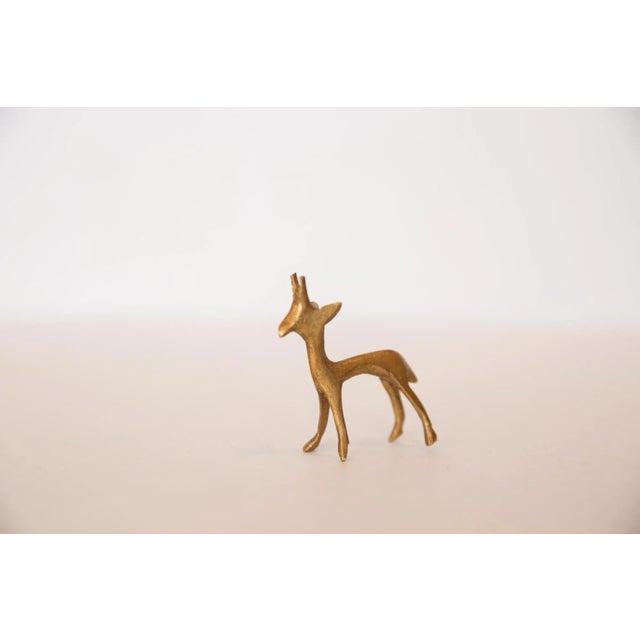 Vintage handmade bronze sculpture of a gazelle fawn (baby gazelle) with a beautiful golden hue. Circa mid 20th century and...