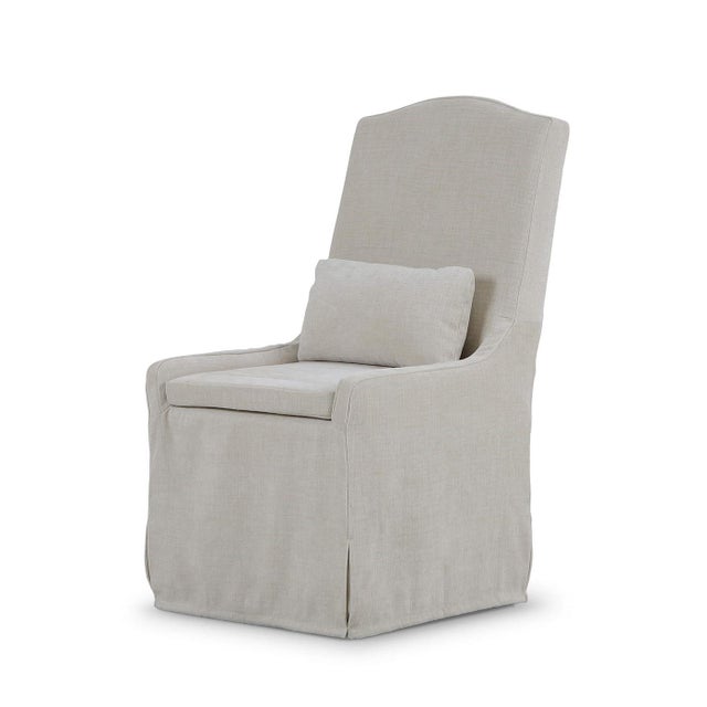 The dining chair in a light bige upholstery blends relaxed comfort and tailored elegance, defined by its high-back...