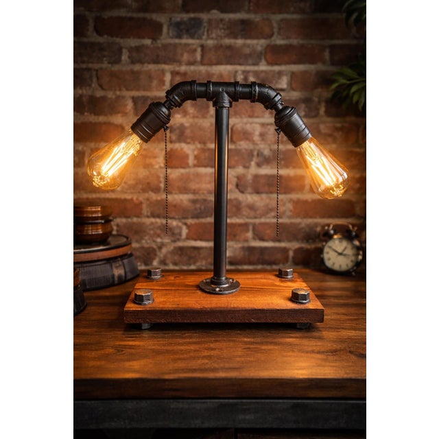 This distinctive industrial-style table lamp features an authentic metal pipe construction paired with a solid stained...