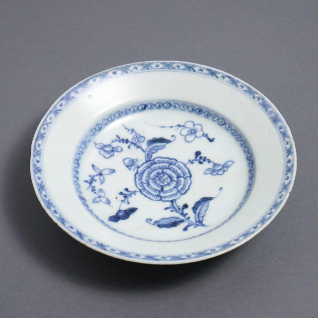 Chinese export porcelain rim soup decorated in cobalt underglaze blue. The pattern centers on a blooming flower surrounded...