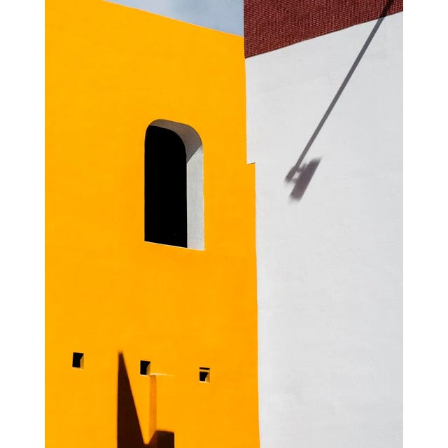 Merida is a bold, color-forward photograph that turns light, shadow, and shape into a graphic statement. Dominated by...