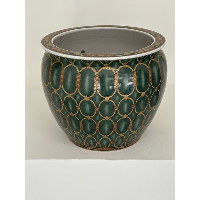 The Planter: A beautiful, deeply glazed ceramic fishbowl featuring an intricate, repeating medallion motif in a rich,...