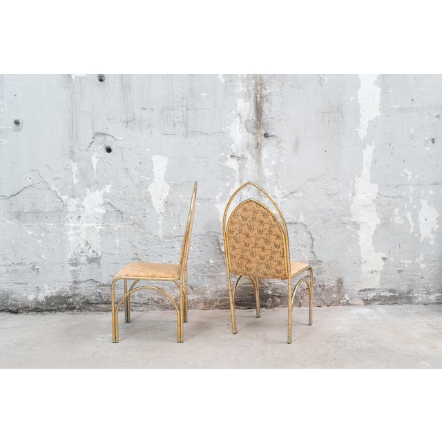 Set of four Italian dining chairs with a gilded metal frame imitating bamboo. Pointed arched backrest. Upholstered seat...