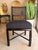 Contemporary coastal dining chair featuring a sleek black wood frame paired with a woven cane back for a sophisticated...