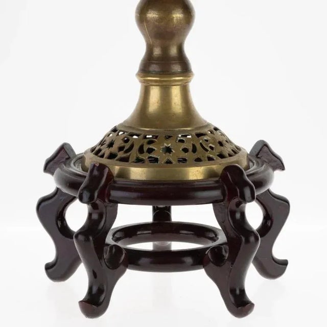 The Antique Indian Pierced Bronze Incense Burner On Wooden Stand stands as a symbol of refined craftsmanship and legacy....