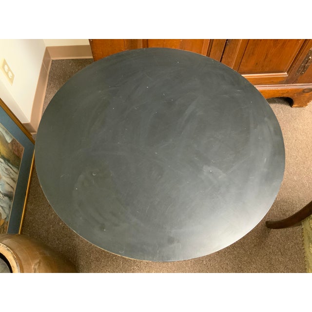 20th century Ethan Allen black lacquered round side table from the maker’s “American Artisan” collection with a carved...
