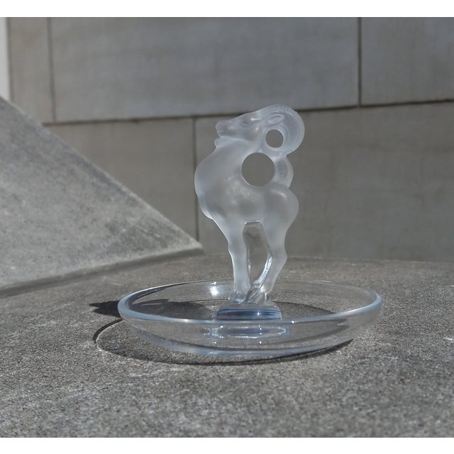 A striking Ring Tray from Lalique France, this exemplar features a prideful and elegant frosted ram at center of a...