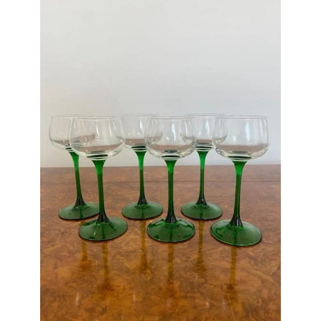 Set of six quality Edwardian wine glasses with green stems on a circular base
