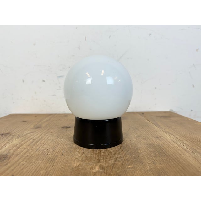 Vintage industrial brown bakelite lamp made in former Czechoslovakia during the 1960s. It features a bakelite wall or...