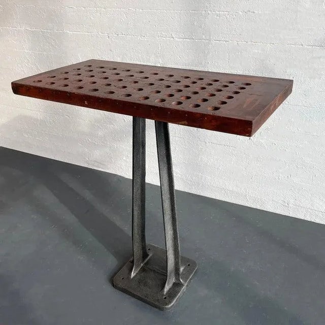 This custom-built industrial console table features a newly brushed, cast iron machine base with a rounded corner floor...