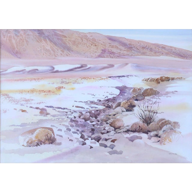 Beautiful watercolor landscape of a rocky arroyo with native plants and distant mountains near Death Valley National Park,...