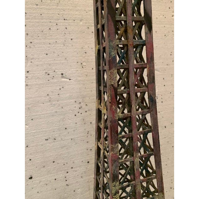 Eiffel Tower made of flat iron and welded, patinated angle iron Lighting system at the base Dimensions: H 185 x W 60 x D...