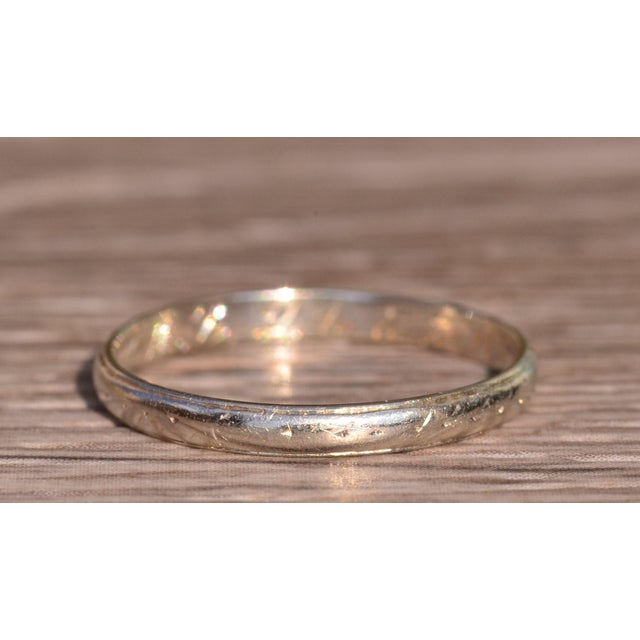 The Cape Range: Antique 18 Karat White Gold Wedding Band Circa 1926. The band features a delicate engraving on the...