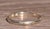 The Cape Range: Antique 18 Karat White Gold Wedding Band Circa 1926. The band features a delicate engraving on the...