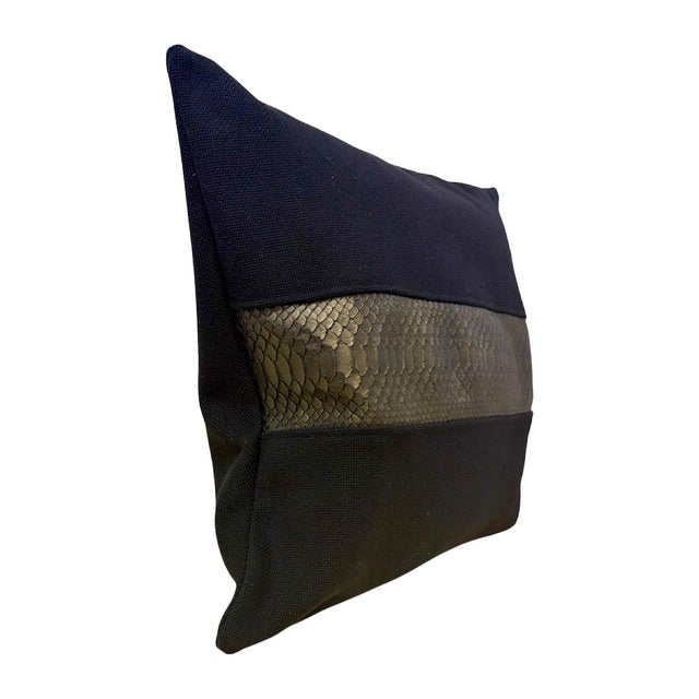 Handcrafted decorative pillow featuring textured black upholstery fabric accented with a striking metallic gold snakeskin...